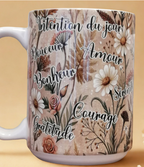 “Mug blanc décoré d’affirmations positives entourées de fleurs.”
